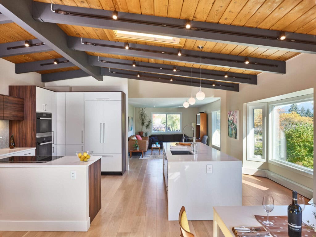 reVISION Family Recipe Custom renovation Kitchen and Living- wood grained cabinets, white quartz and large island - open rafters