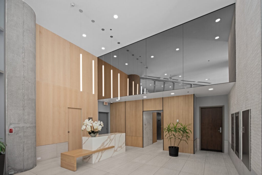 reVISION Modern Lobby renovation - Yaletown Vancouver - Wood panels white quartz grey tile large mirrors modern pendant lights