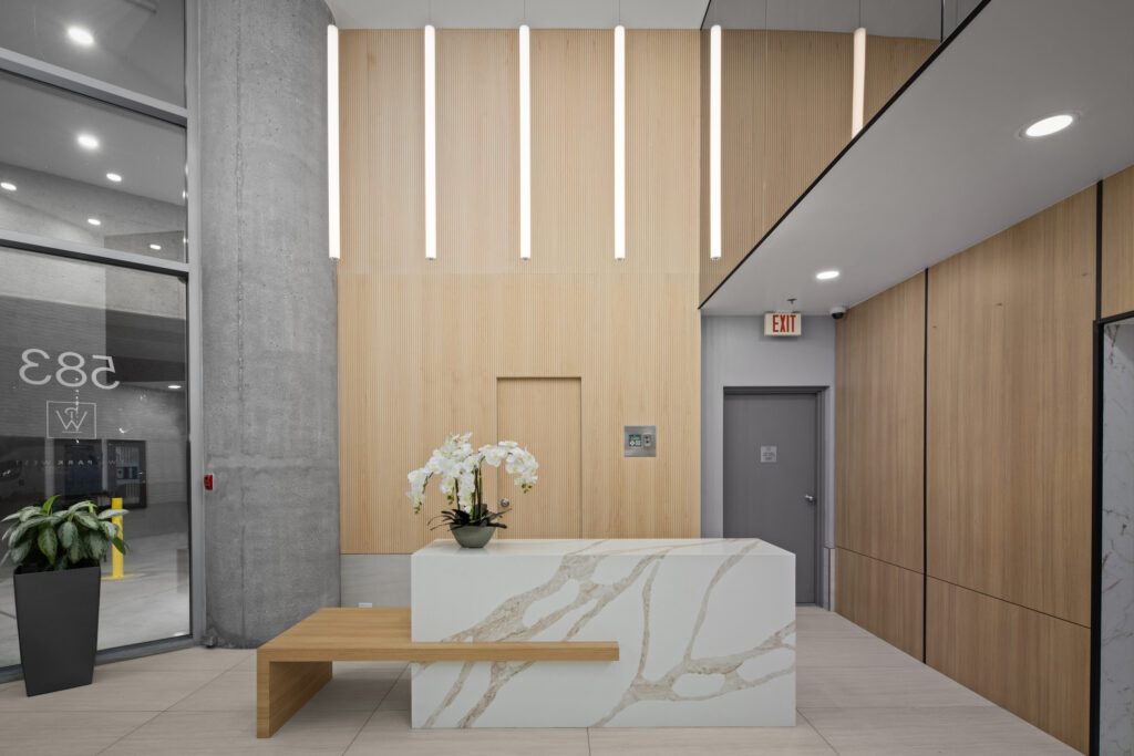 reVISION Modern Lobby renovation - Yaletown Vancouver - Wood panels white quartz grey tile large mirrors modern pendant lights