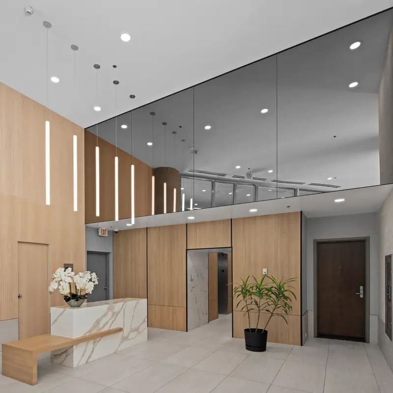 reVISION Modern Lobby renovation - Yaletown Vancouver - Wood panels white quartz grey tile large mirrors modern pendant lights